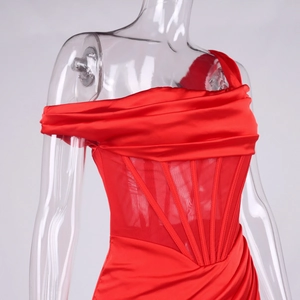 Détail de la robe en satin rouge avec baleines de corset et empiècements en résille à la taille