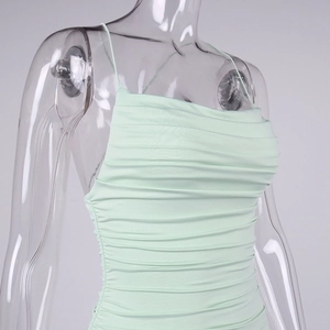 Close-up of mint green ruched fabric and thin shoulder straps on a slim fit summer dress