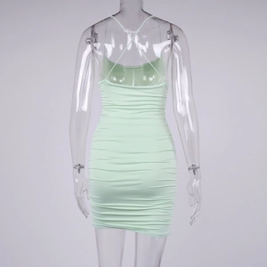 Detail of mint green ruched bodycon dress showing strappy criss-cross back design