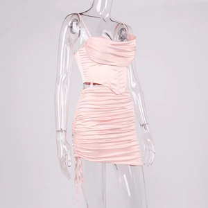 Détail d'un ensemble satin rose clair avec jupe froncée et haut de type corset