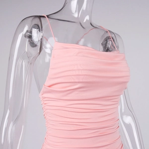 Detail of ruched fabric and pink bodycon silhouette on a backless mini dress