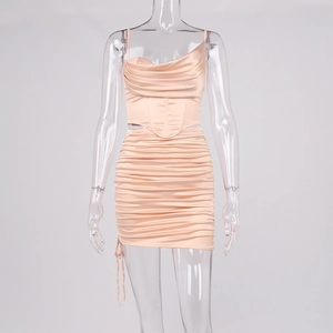 Détail d'un ensemble satiné rose clair avec haut court bustier et mini-jupe froncée chic