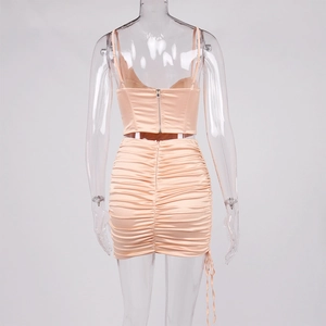 Détail d'un ensemble deux pièces en satin rose avec jupe froncée et zip au dos