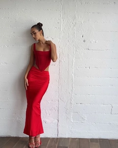 Détail du haut corset en satin rouge avec jupe moulante froncée assortie et talons