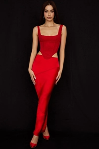 Détail d'un haut corset rouge avec baleines et jupe longue en satin brillant de soirée