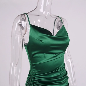 Detail of emerald green satin slip dress with cowl neck and side ruched texture