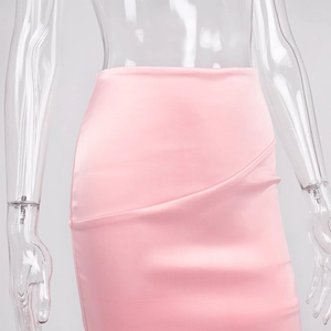 Détail d'une jupe en satin rose clair coupe ajustée avec design asymétrique superposé