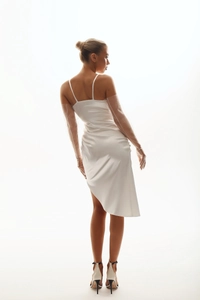 Détail de la robe en satin blanc avec ourlet asymétrique et design dos nu élégant
