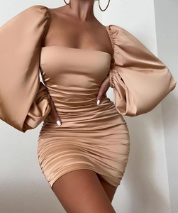 Détail de la robe mini en satin champagne avec encolure carrée et texture froncée élégante