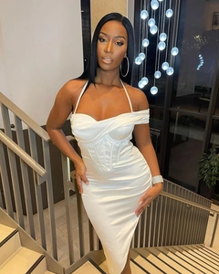 Detail of white satin corset midi dress with halter neck and side slit in indoor setting