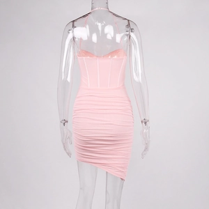 Detail of light pink corset dress featuring ruched back and asymmetric hemline