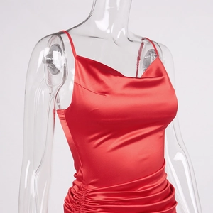 Detail of red satin dress featuring cowl neck, thin straps, and elegant ruched texture