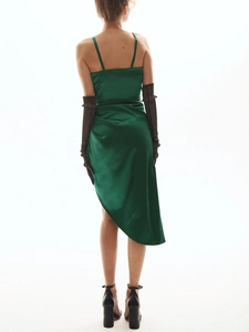 Détail d'une robe midi en satin vert émeraude avec dos nu et ourlet asymétrique élégant