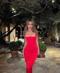 Détail de la robe en satin rouge avec col carré, taille plissée et drapé élégant