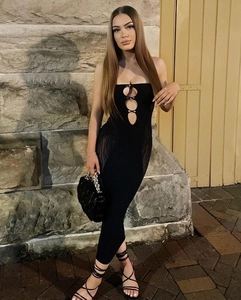 Detail of black strapless midi dress featuring three oval cut-outs and metal buckles