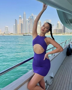 Détail d'une robe mini dos nu violette sur un yacht avec vue urbaine de luxe
