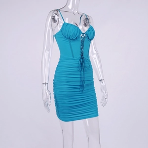 Détail d'une mini robe bleu sarcelle avec buste lacé et tissu froncé moulant