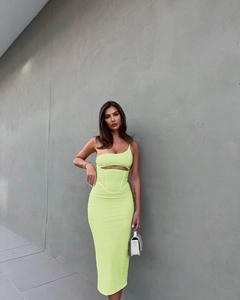 Detail of neon green one-shoulder bodycon dress with waist cutout and ribbed texture