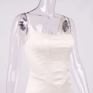 Détail d'un haut corset en satin blanc cassé avec coutures et ourlet en pointe