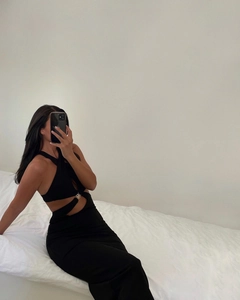 Detail of cutout waist with gold metal ring on black halter neck bodycon maxi dress