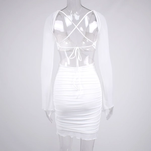 Close-up of the backless white ruched dress with criss-cross lace-up straps and long sleeves