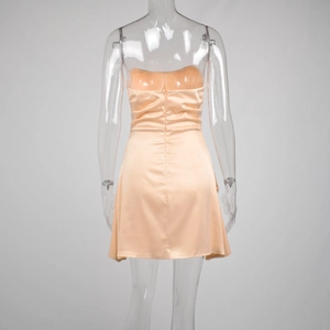 Detail view of champagne satin dress back with zipper and pleated corset design