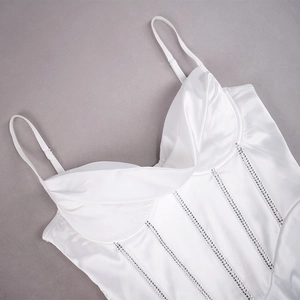 Détail du haut corset en satin blanc avec lignes en strass et design de poitrine plissé