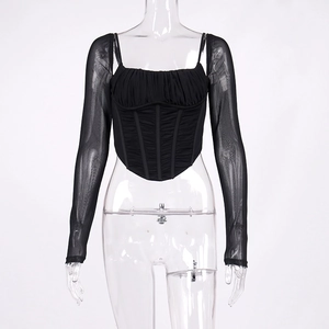 Dettaglio del top a corsetto nero con maniche in mesh e struttura a stecche interne