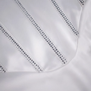 Détail d'une robe en satin blanc avec des bretelles verticales élégantes et strass argentés