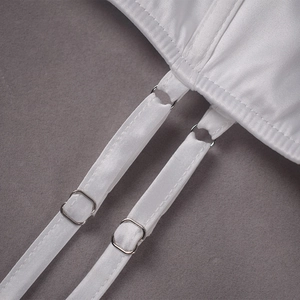 Détail de la bretelle de robe en satin blanc avec boucle en métal argenté sur fond gris