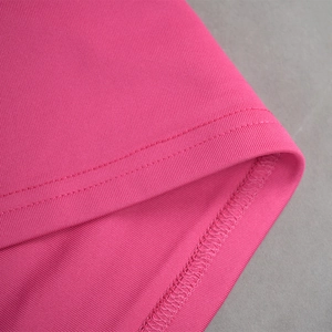 Gros plan détaillé des coutures doubles et de la finition de l'ourlet d'une robe en tricot rose