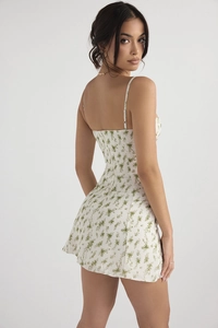 Détail d'une mini robe blanche à fleurs avec fines bretelles et fermeture éclair