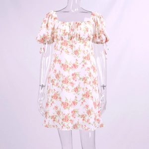 Detail of floral puff sleeves with adjustable bow ties on a white summer A-line dress