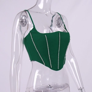 Détail macro du haut corset vert foncé avec des chaînes en strass sur le corsage