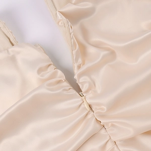 Nahaufnahme der champagnerfarbenen Satin-Textur mit Hochglanz-Finish und verdecktem Reißverschluss