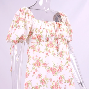 Detailed view of puff sleeves and floral rose print on a white square neck dress