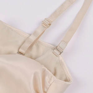 Detail der verstellbaren Träger und Champagner-Satin-Stoff an einem ärmellosen Kleid