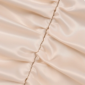 Detailansicht aus champagnerfarbenem Satin mit elegantem Raffungs-Effekt und Glanz
