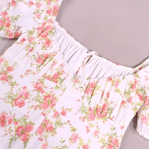 Detail view of floral A-line dress featuring a U-neckline with pleated drawstring and puff sleeves