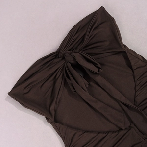 Detail of ruched chocolate brown dress fabric featuring lace-up bow design and open back