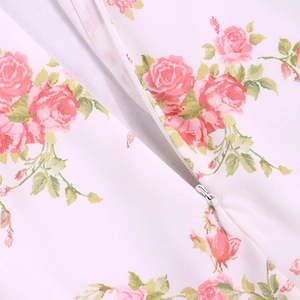 Detailed macro shot of the hidden zipper and pink rose floral print on a white summer dress
