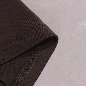 Macro detail of dark coffee knit fabric with ribbed texture and double-needle stitching