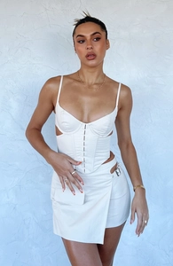 Detail of white corset top with V-neckline and mini skirt featuring metal buckle