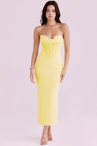 Detail of a bright yellow corset maxi dress with elegant pleats and structured boning
