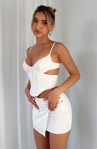 Detail of white corset crop top with side cut-out and matching bodycon mini skirt