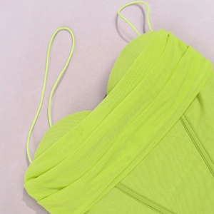 Detail of neon green mesh corset top featuring thin straps and structured boning seams