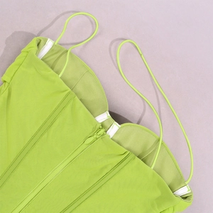 Detail view of neon green corset top with back zipper and structural bone stitching