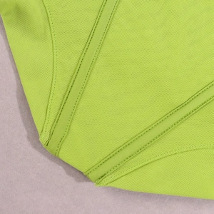 Detailed close-up of fluorescent green mesh bodice with structural boning and satin trim