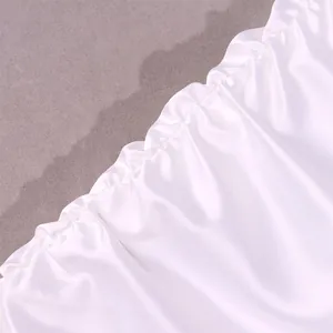 Close-up detail of white satin fabric with elegant shirred edges and silk-like glossy finish