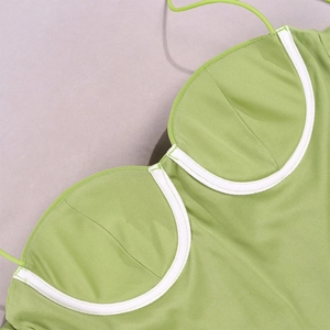 Detail of light green mesh corset top featuring white contrast piping and bustier stitching
